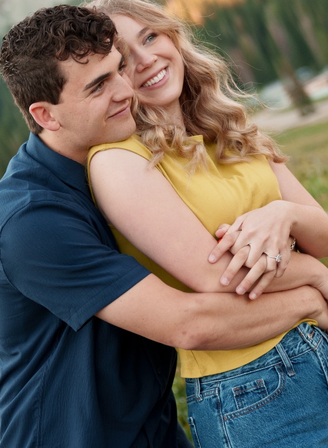 Emmaline and Clark Jr. embracing in a mountain meadow