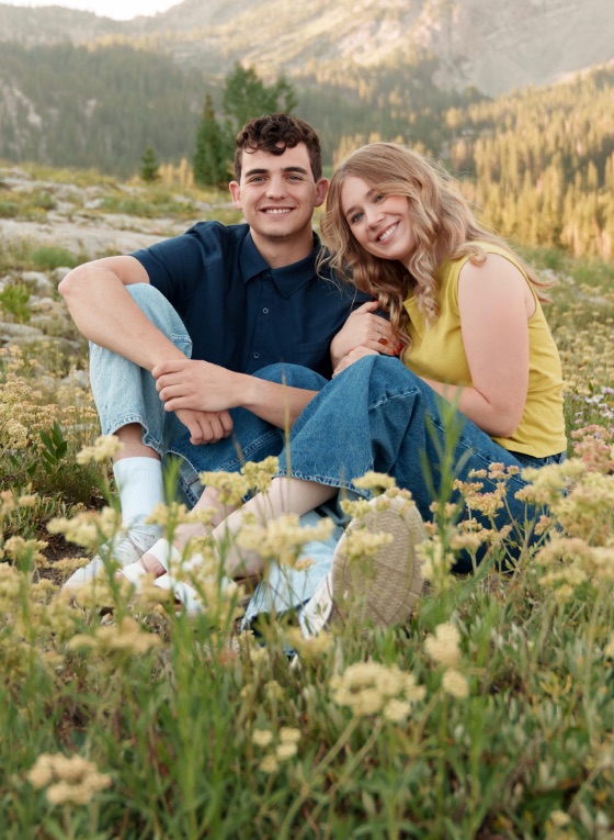 Emmaline and Clark Jr. sitting together in a mountain meadow